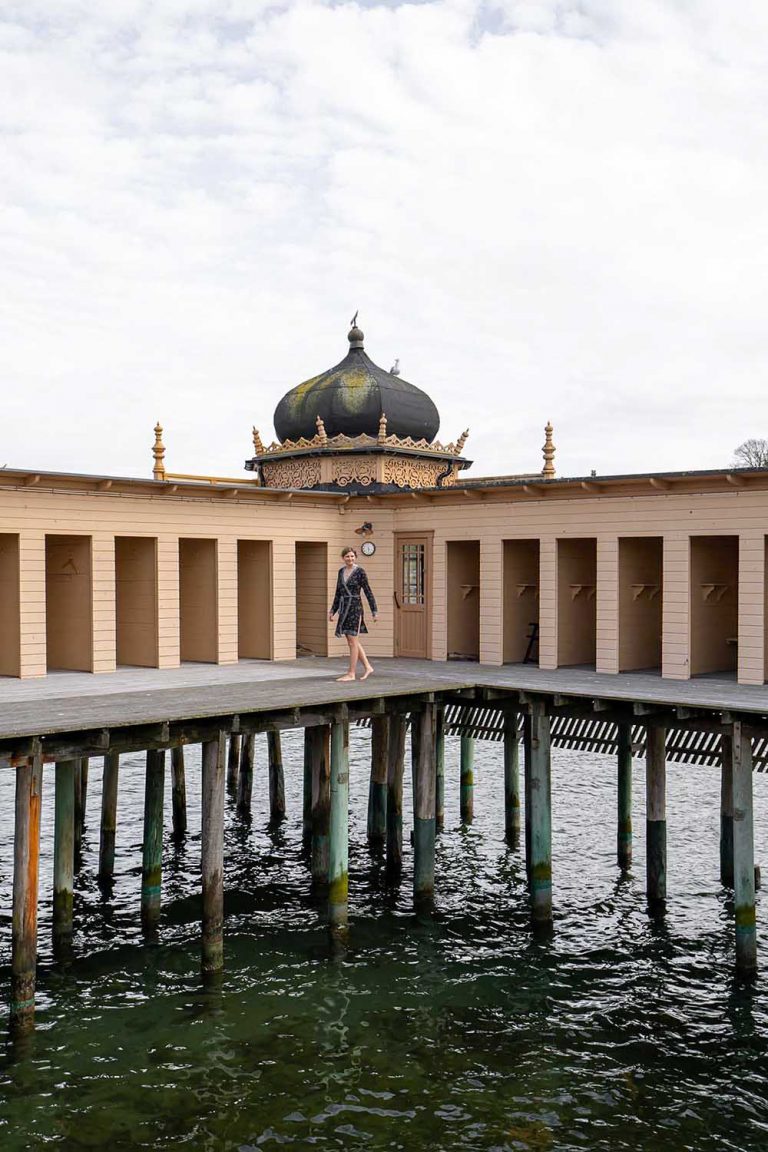 Das Kaltbadhus in Schweden ist sehr bekannt und beliebt. Die Bloggerin Judith Beck ist vor der historischen Kulisse des Kaltbadhus mit seinen Stelzen im Wasser.