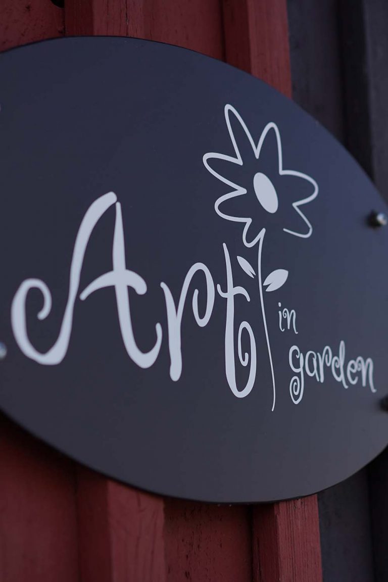 Ein Schild auf dem Art im Garten geschrieben steht.
