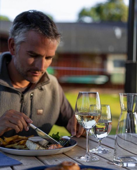 Der Blogger Jesús Tena vom Fernzeit Reiseblog sitzt an einem gedeckten Tisch in einem gehobenen Fischrestaurant. Es ist mitten auf dem Land, der Fisch ist weithin bekannt und frisch gefangen.